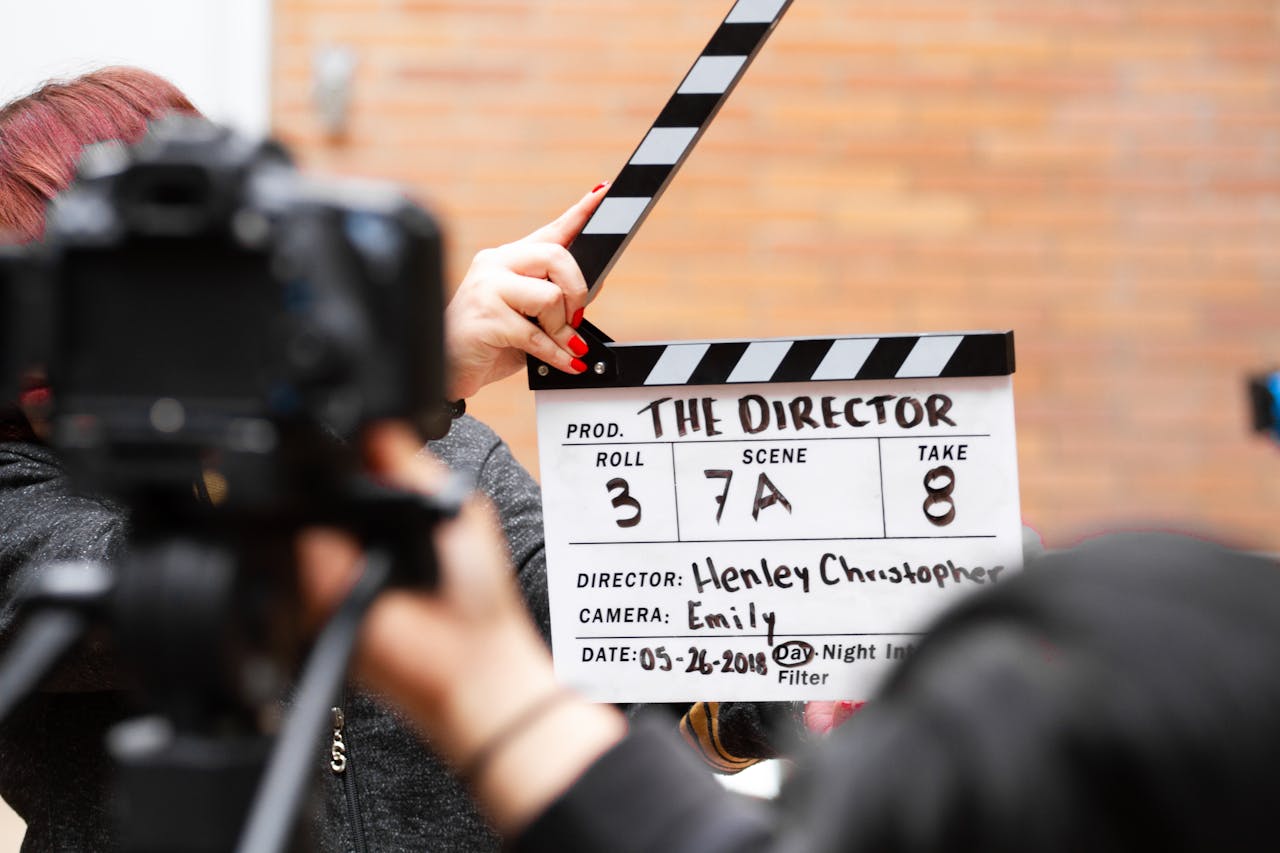 gallery-6 Close-up of film clapperboard in action with camera filming a take on set.
